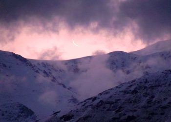 La luna apenas sugerida en una delgada curva blanca parece esconderse tras las nubes y las cumbres del mágico Cordón del Plata. (Foto: Ana Vogel)