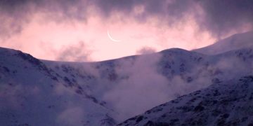 La luna apenas sugerida en una delgada curva blanca parece esconderse tras las nubes y las cumbres del mágico Cordón del Plata. (Foto: Ana Vogel)