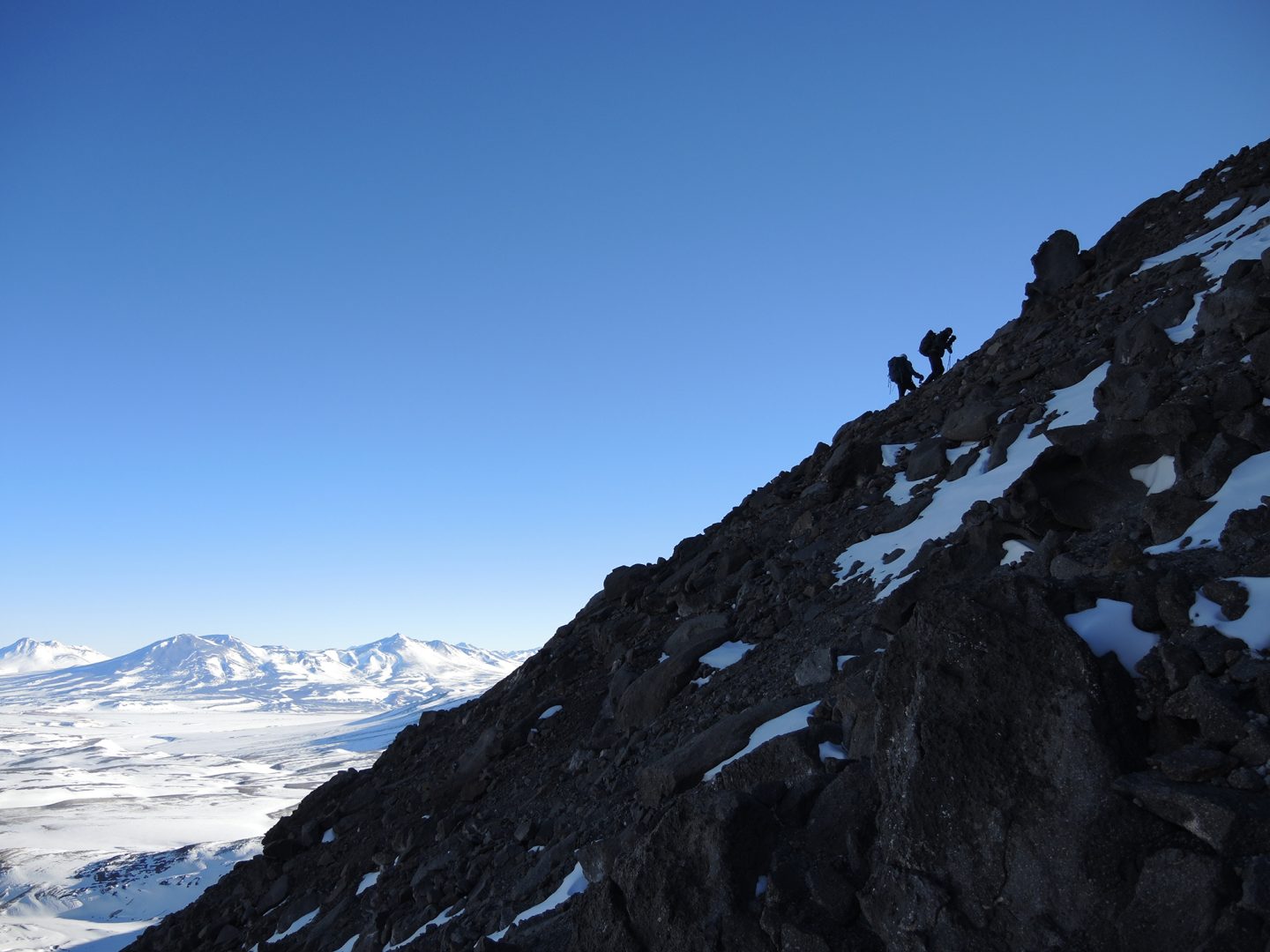 Los montañistas trepando el hombro del filo en el nevado El Muerto.