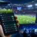 Celular con cuotas de apuestas en vivo frente a un estadio deportivo iluminado