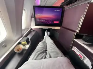 Virgin Atlantic Upper Class seat with in-flight screen, drink and snack beside the window
