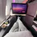Virgin Atlantic Upper Class seat with in-flight screen, drink and snack beside the window