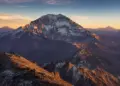 Dos montañistas frente a un gran macizo nevado de los Andes argentinos al amanecer